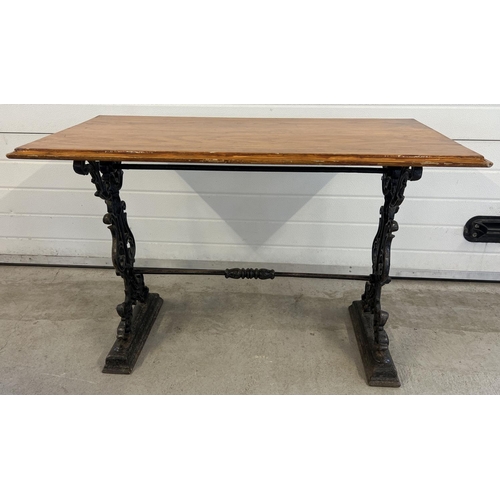 1348 - A vintage wooden topped table with cast iron base. Painted black cast iron legs with scroll, floral ... 