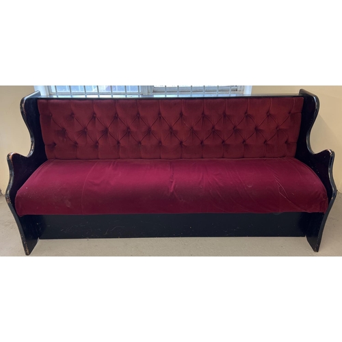 1358 - A vintage painted black wooden pub bench seat with button back red velour upholstery and shaped side... 