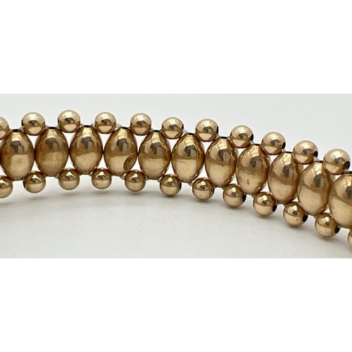 25 - A 14ct gold oval and round bead elasticated bracelet, approx. 7 inches long. Total weight approx. 3.... 