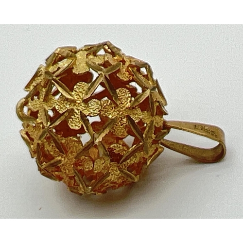 1 - A 9ct gold ball shaped pendant with pierced floral design, on a fixed hanging bale. Full hallmarks o... 