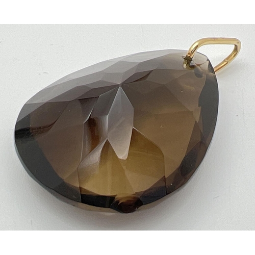 94 - A large, faceted teardrop cut smoked quartz stone pendant on a 14ct gold hanging bale. Pendant appro... 