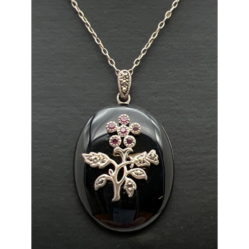 112 - A vintage silver onyx, ruby and marcasite pendant on an 18