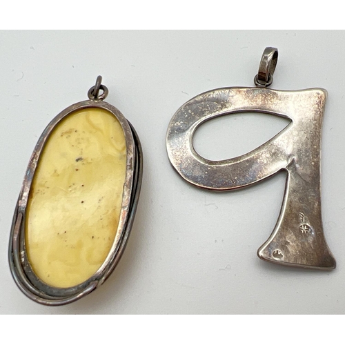 104 - 2 silver pendants. An oval modern design pendant set with butterscotch amber together with a blue en... 