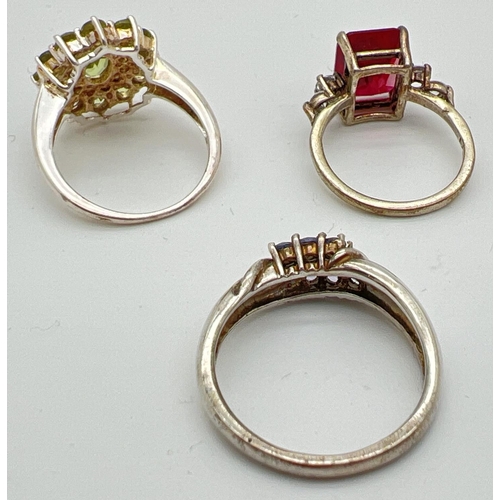 47 - 3 silver stone set dress/cocktail rings. A square cut red spinel with two round cut clear stones to ... 