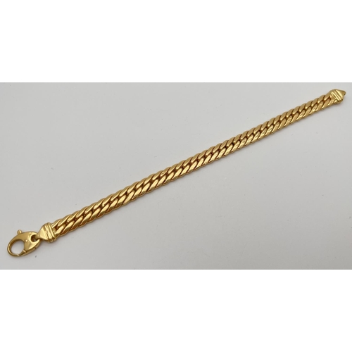 52 - An 18ct gold Cuban link chain bracelet with lobster claw clasp. Approx. 8.5 inches long and 8 mm wid... 