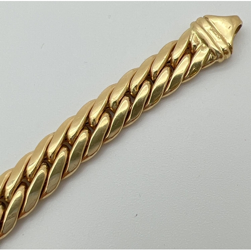 52 - An 18ct gold Cuban link chain bracelet with lobster claw clasp. Approx. 8.5 inches long and 8 mm wid... 