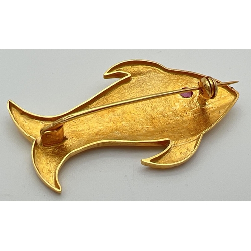 54 - A 22ct gold brooch in the shape of a fish set with oval cut ruby eye. Patterned detail to body with ... 