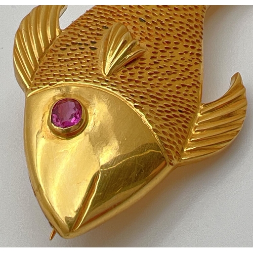 54 - A 22ct gold brooch in the shape of a fish set with oval cut ruby eye. Patterned detail to body with ... 