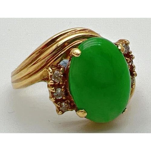 56 - A vintage 14ct gold jade and diamond set dress ring. A twist design mount set with an oval cabochon ... 