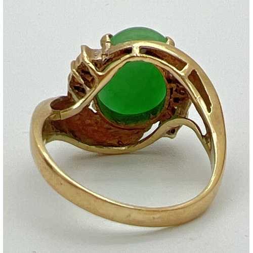 56 - A vintage 14ct gold jade and diamond set dress ring. A twist design mount set with an oval cabochon ... 