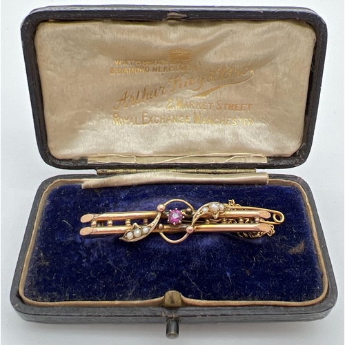 42 - An Edwardian 9ct gold double bar brooch set with a ruby and seed pearls, in original box. A central ... 