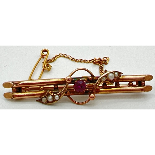 42 - An Edwardian 9ct gold double bar brooch set with a ruby and seed pearls, in original box. A central ... 