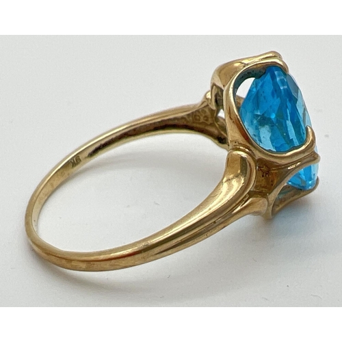 60 - A 9ct gold dress ring set with a large oval cut Swiss blue topaz in a decorative mount. Full hallmar... 