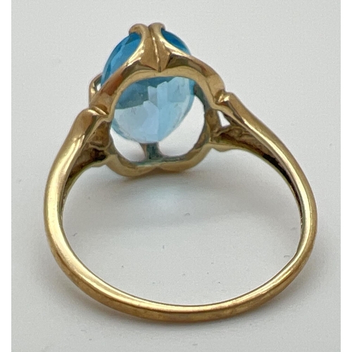 60 - A 9ct gold dress ring set with a large oval cut Swiss blue topaz in a decorative mount. Full hallmar... 