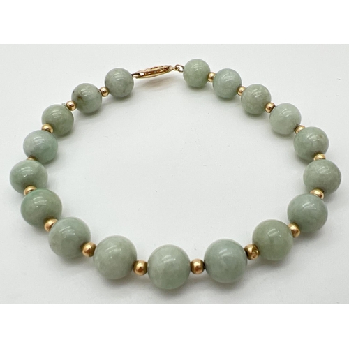 8 - A green jade and 14ct gold bead bracelet with pierced work fishhook clasp. Alternating round green j... 