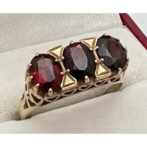 69 - A 9ct gold vintage style garnet set trilogy ring. Decorative high mount with heart design pierced wo... 