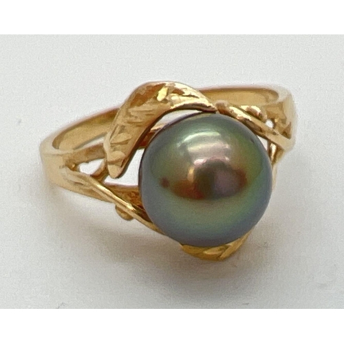 70 - A 14ct gold dress ring set with a large round gunmetal grey pearl. With leaf and vine design mount. ... 