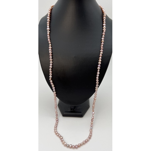 75 - A 35 inch string of pale pink freshwater pearls in varying shapes and lustres.