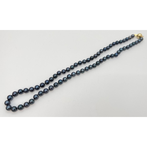 76 - An 18 inch knotted black pearl necklace with 9ct gold ball push clasp. Gold marks to clasp.