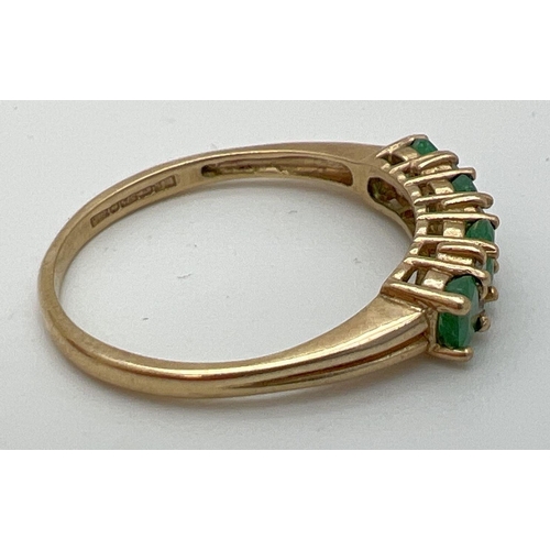 78 - A 9ct gold emerald and diamond set half eternity ring. 4 round cut emeralds with 2 small round cut d... 