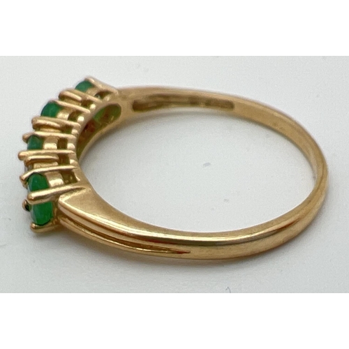 78 - A 9ct gold emerald and diamond set half eternity ring. 4 round cut emeralds with 2 small round cut d... 