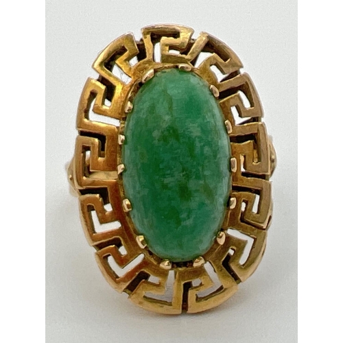 83 - A vintage 14K gold dress ring set with an oval green jade cabochon in a high shoulder decorative ova... 