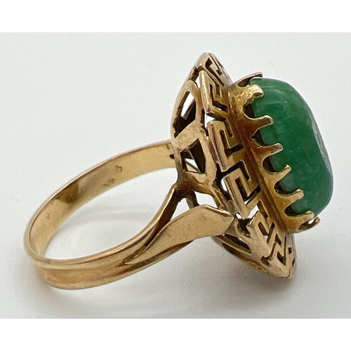 83 - A vintage 14K gold dress ring set with an oval green jade cabochon in a high shoulder decorative ova... 