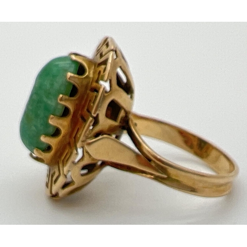 83 - A vintage 14K gold dress ring set with an oval green jade cabochon in a high shoulder decorative ova... 