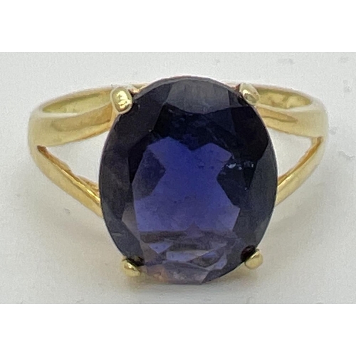 89 - A 14K gold dress ring with a large oval cut claw set dark blue tanzanite stone. Gold marks to inside... 