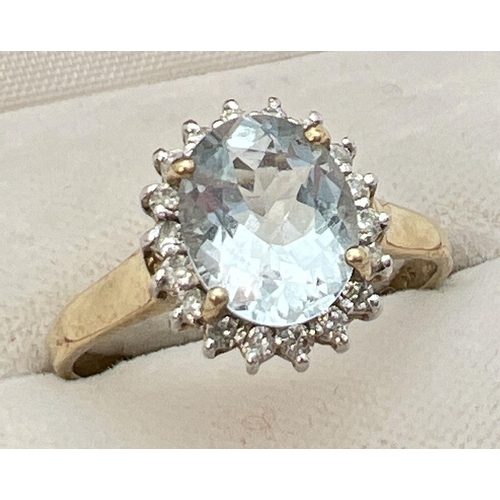 51 - A 9ct gold aquamarine and diamond halo style dress ring. A central oval cut aquamarine (10mm x 8mm) ... 