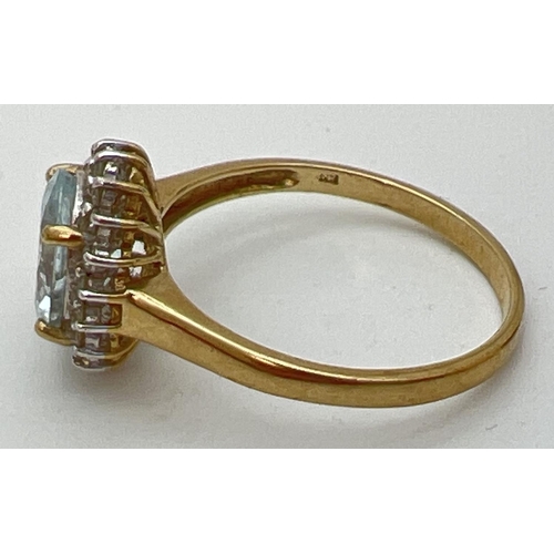 51 - A 9ct gold aquamarine and diamond halo style dress ring. A central oval cut aquamarine (10mm x 8mm) ... 