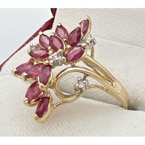 22 - A 14ct gold ruby and diamond set dress ring in a flower design mount. 12 marquise cut small rubies t... 