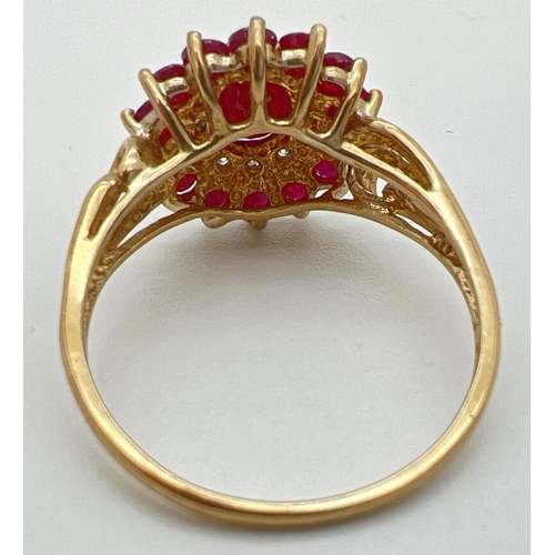 10 - A 9ct gold cluster style ruby and diamond dress ring with scroll detail to shoulders. Central oval c... 