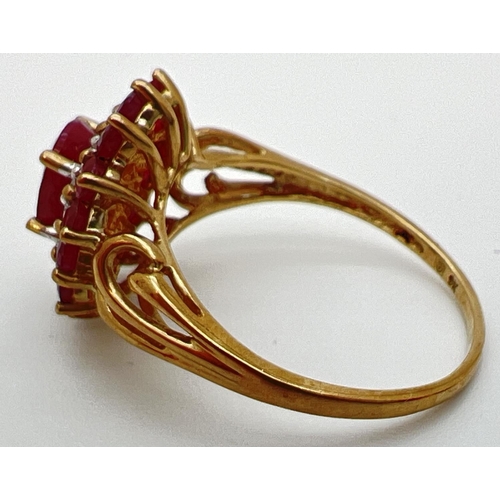 10 - A 9ct gold cluster style ruby and diamond dress ring with scroll detail to shoulders. Central oval c... 