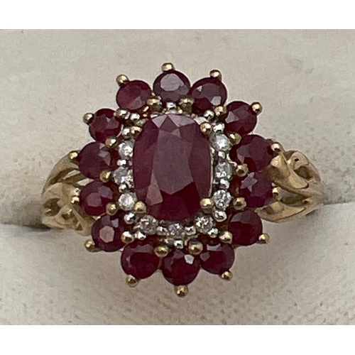 10 - A 9ct gold cluster style ruby and diamond dress ring with scroll detail to shoulders. Central oval c... 