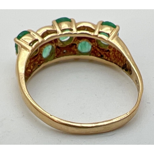 110 - A vintage style 14K gold, emerald and diamond dress ring. Two rows of oval cut emeralds with alterna... 