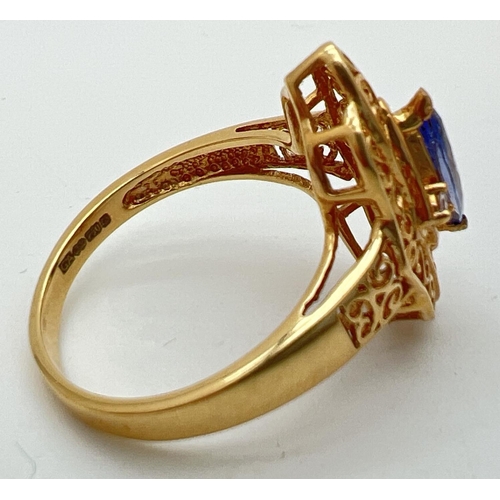 33 - An 18ct gold, Ceylon sapphire ring with pierced work decorative mount. Set with a marquise cut centr... 