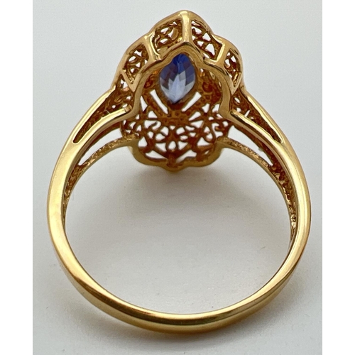 33 - An 18ct gold, Ceylon sapphire ring with pierced work decorative mount. Set with a marquise cut centr... 