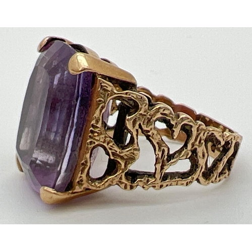 113 - A vintage 9ct gold statement cocktail ring set with a large square cut amethyst in an open work bark... 