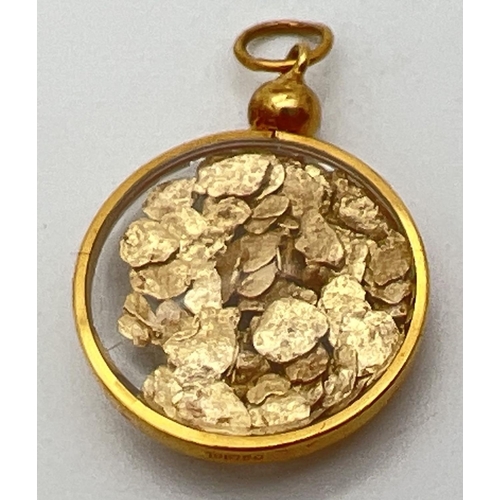 116 - An 18ct gold and glass pendant filled with small natural gold flakes, complete with hanging bale. Go... 