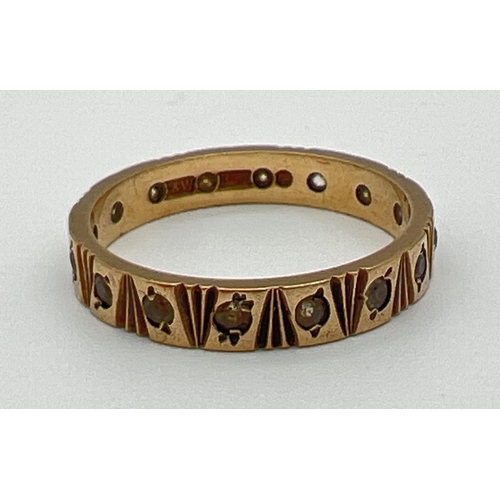 1122 - A vintage full eternity ring with engraved pattern and set with small round cut clear stones. Full h... 