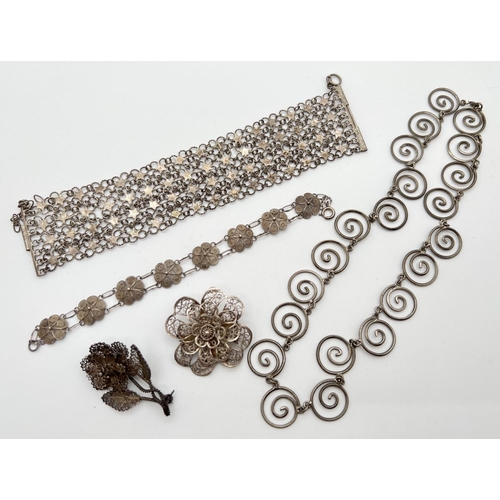 1124 - A small collection of vintage white metal jewellery. To include floral design brooches, a multi stra... 