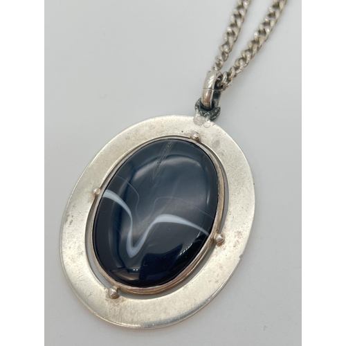 1133 - A large white metal pendant set with an oval black agate stone, on a 20