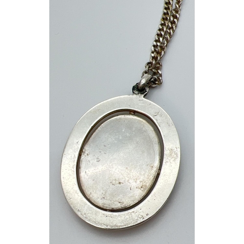 1133 - A large white metal pendant set with an oval black agate stone, on a 20