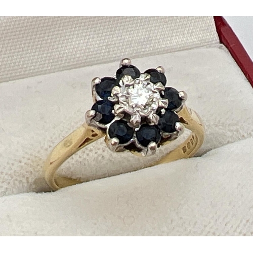 1135 - An 18ct gold diamond and sapphire ring. Central 0.07 ct diamond surrounded by 8 round cut sapphires.... 