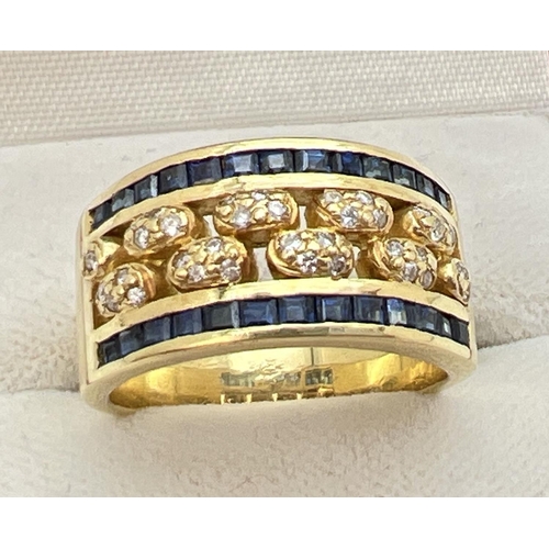 1138 - A gold open work sapphire and diamond band ring. 13 square cut bezel set sapphires to each side with... 