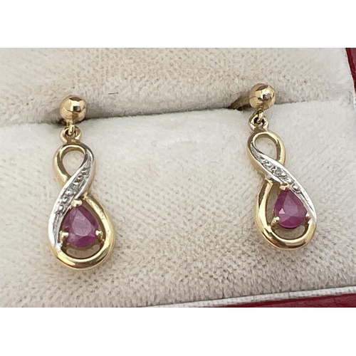 1139 - A pair of unmarked 9ct gold infinity twist drop earrings set with teardrop rubies and diamond chips.... 