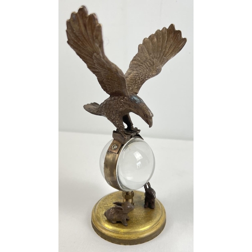 1213 - An ornamental brass ball clock with eagle shaped finial and rabbit figures to base. With wind up mec... 