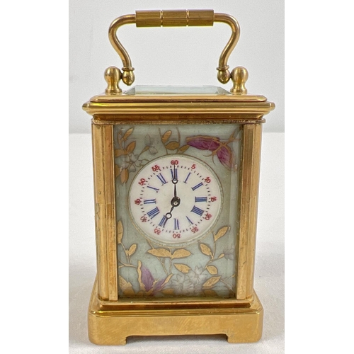 1206 - A miniature brass cased carriage clock with hand painted porcelain panels. Bevel edged glass, gilt d... 