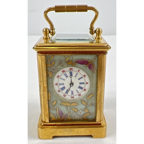 1206 - A miniature brass cased carriage clock with hand painted porcelain panels. Bevel edged glass, gilt d... 